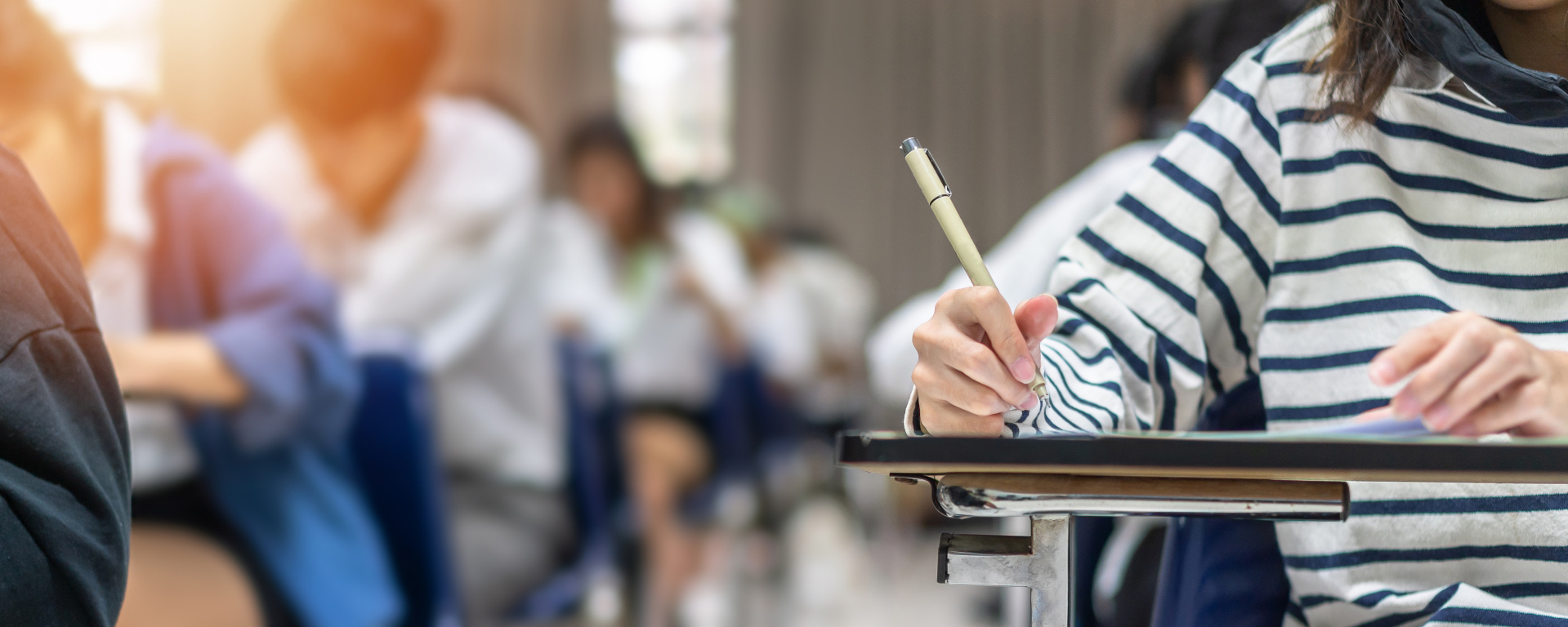 Examination at school, where students take an entrance test in class, think hard and write answers in a university lecture theatre, concept for Education and World Literacy Day