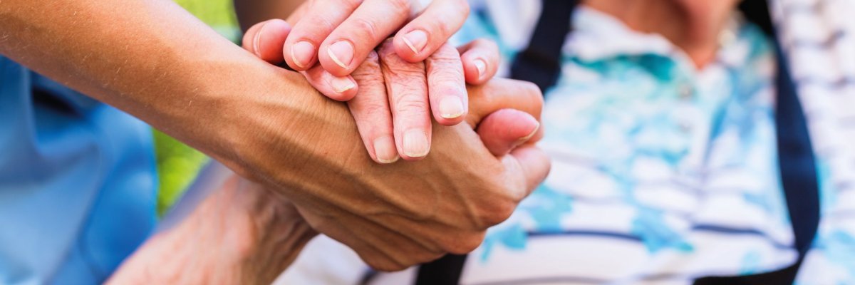 Nurse consoling senior woman holding her hand