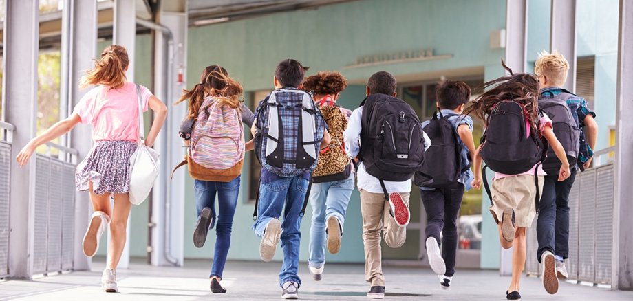 Niños en la escuela Grupo de alumnos caminando por el pasillo de la escuela.