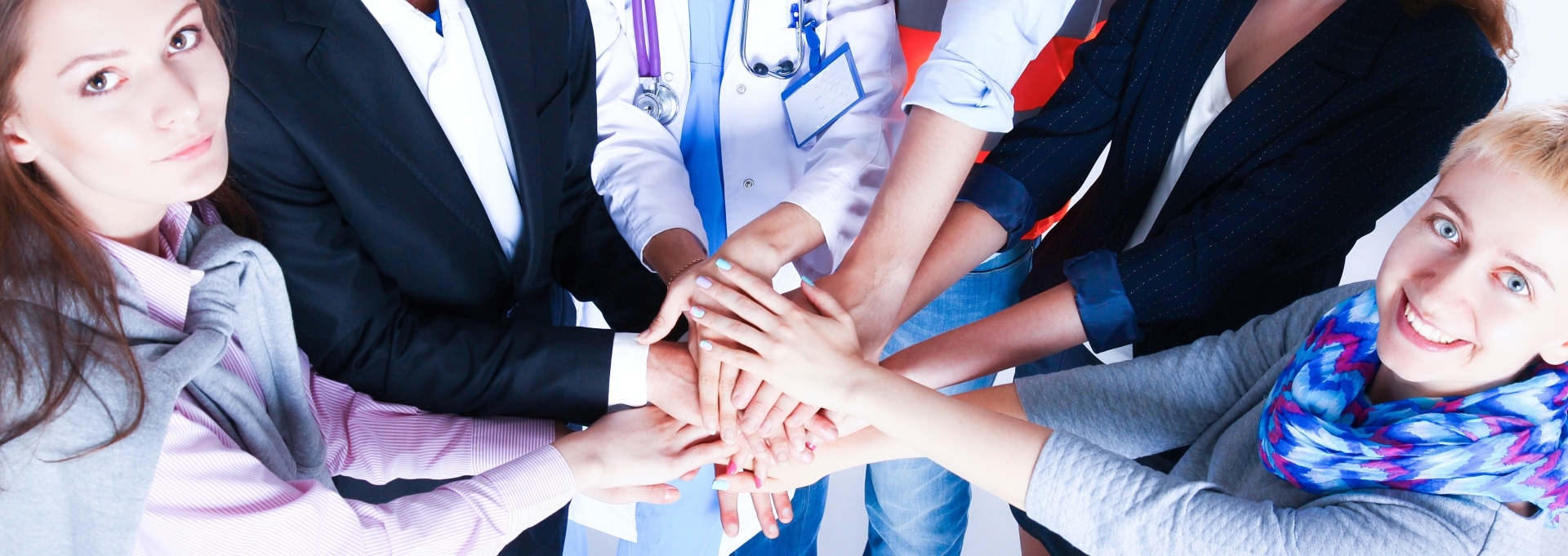 Menschen stehen im Kreis und legen die Hände übereinander.