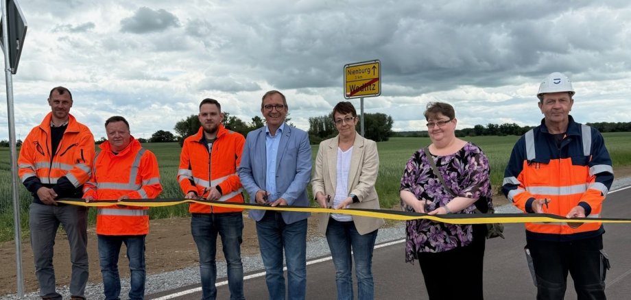 El administrador del distrito, Markus Bauer (4º por la izquierda), y la alcaldesa de Nienburg, Susann Falke (5ª por la izquierda), en la inauguración oficial de la carretera comarcal 2101, cerca de Wedlitz. También se puede ver a otras personas implicadas en la renovación.