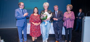 De izquierda a derecha: Sr. Markus Bauer, Administrador del Distrito de Salzlandkreis; Sra. Dorothée Vatterott, Responsable de Marketing/Relaciones Públicas de Stadtwerke Schönebeck GmbH; Sra. Sandy Schützmannsky, Ganadora Honoraria del Premio; Sr. Bert Knoblauch, Alcalde de Schönebeck (Elba); Sra. Andrea Alzuro López, Responsable de Igualdad de Oportunidades del Ayuntamiento de Schönebeck (Elba); al fondo: Sr. Frank Sieweck, Moderador de la ceremonia de entrega de premios (Gestión Municipal/Portavoz de Prensa de EMS Energie Mittelsachsen GmbH).