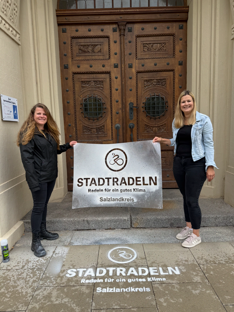 Kati Steinhausen (izquierda) y Luisa Brune, del distrito de Salzlandkreis, han colocado el logotipo frente a la sede de la administración del distrito en Bernburg. Kati Steinhausen (izquierda) y Luisa Brune, del distrito de Salzlandkreis, han colocado el logotipo frente a la sede de la administración del distrito en Bernburg.