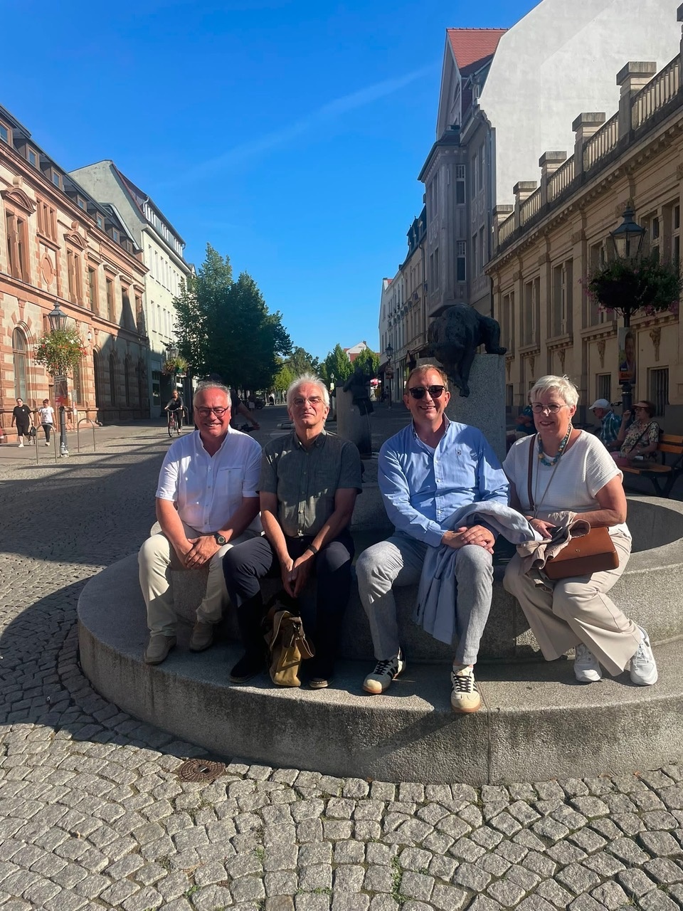 Stefan Schwenke, maire de Worpswede (à gauche sur la photo), à Bernburg, en compagnie de Markus Bauer, conseiller régional (3e à partir de la gauche), devant une statue en bronze représentant le jeu du « téléphone arabe »