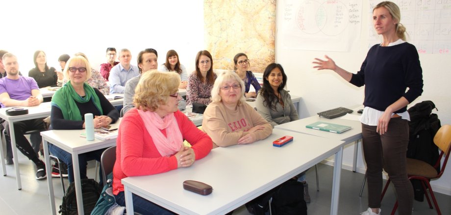 Julia Fröhlich (Dozentin bei der KVHS Salzlandkreis) spricht vor den Teilnehmenden des Integrationskurses.